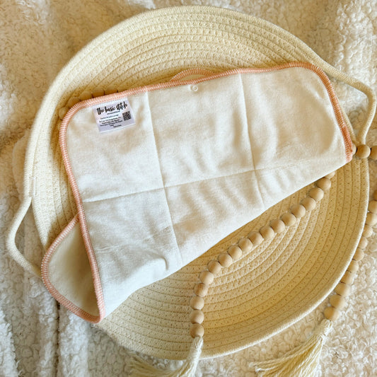 Bamboo Velour Topped Hemp Trifold. Folded on a cream colored woven rope basket.