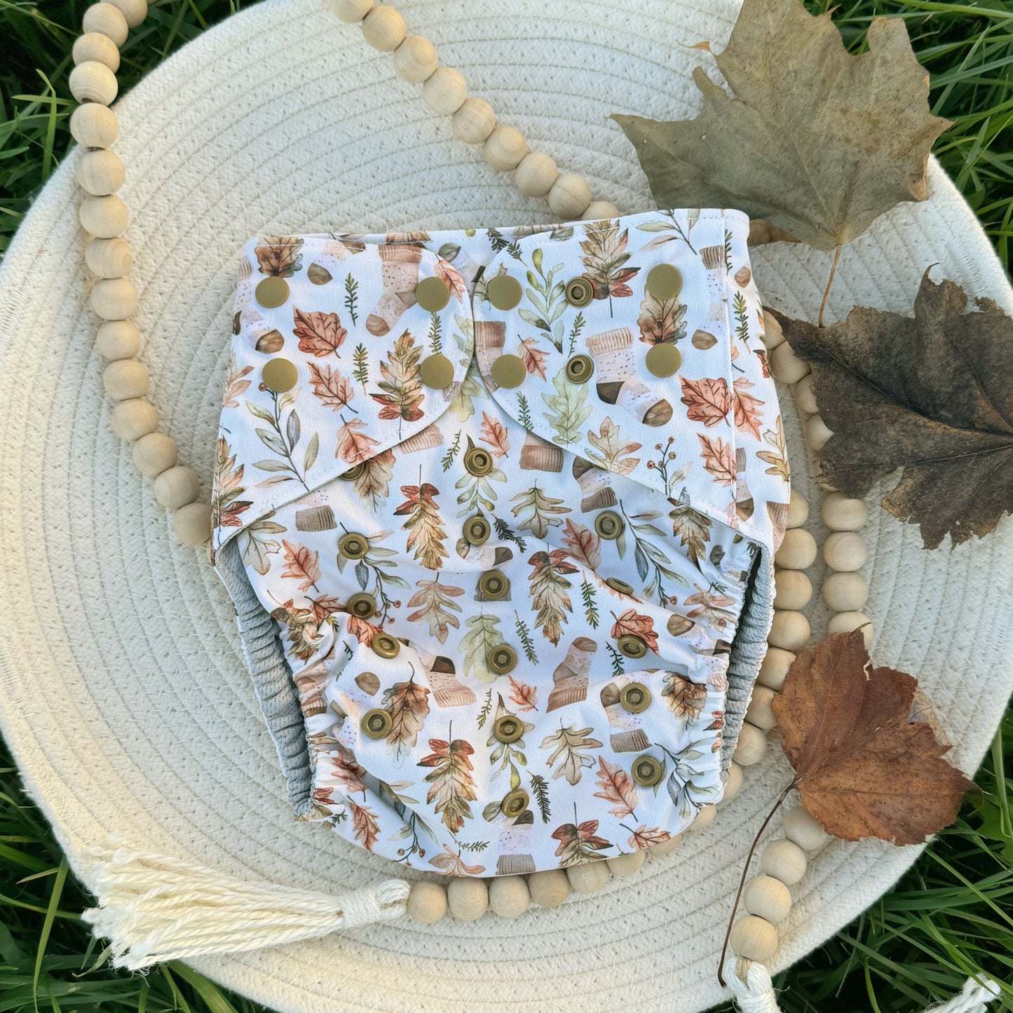 Cozy Beige Stocking Socks on a Tan Background with Leaves and Pine Sprigs